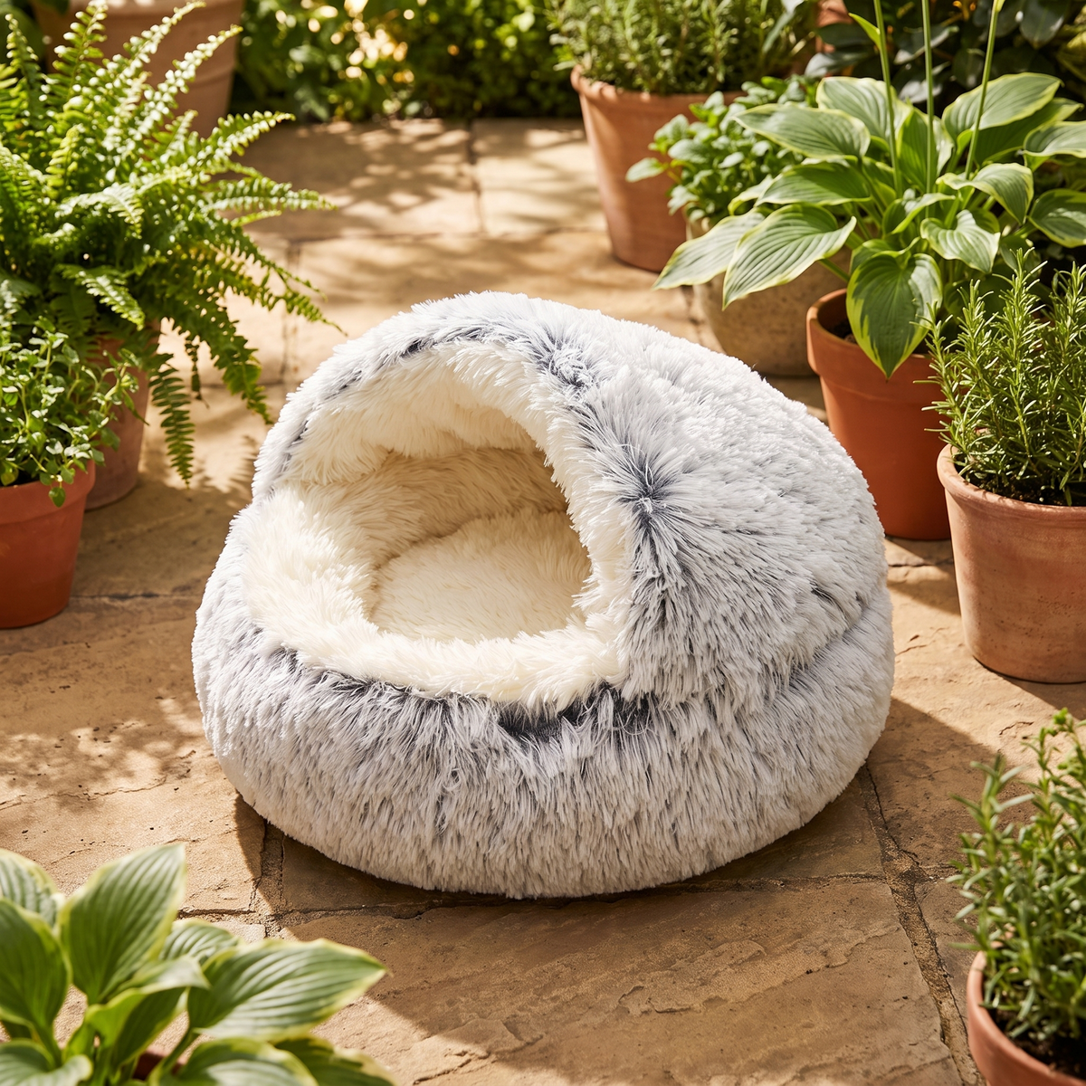 Nestly cat cave bed on stone paving on a sunlit garden terrace